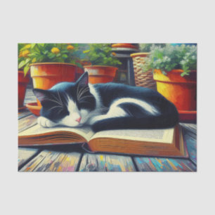 Tuxedo-Katze schläft auf einem Buch im Garten - De Seidenpapier