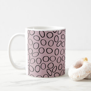 Unregelmäßiges schwarzes Zirkelmuster auf rosa Tasse
