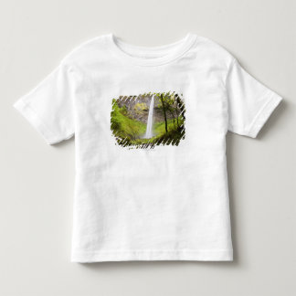 Unscharfer Wasserfall um üppiges Grün in Oregon Kleinkind T-shirt