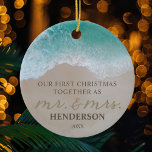 Unsere ersten Weihnachten als Mr. & Mrs. Beach Keramik Ornament<br><div class="desc">Maßgeschneiderte 1. Weihnachten als frisch vermählte Ornament mit einem tropischen Sandstrand,  türkisblaues Meer,  das niedliche Sprichwort "unsere ersten Weihnachten zusammen wie mr. & mrs." teilweise im Sand geschrieben,  Ihr Familienname und das Jahr.</div>