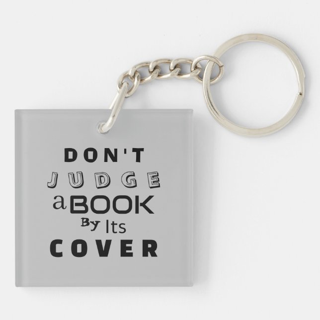 "Urteile ein Buch nicht nach seinem Cover" hellgra Schlüsselanhänger (Rückseite)