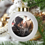 Verlobtes Foto zu Weihnachten Keramik Kugel-Ornament<br><div class="desc">Gedenken Sie Ihre Verlobung mit diesem schönen modernen Sakraldekor. Der weiße Text lautet "Unser erstes Weihnachten verlobt", mit dem Wort "verlobt" in eleganter Handschrift mit Schnörkeln vor und nach. Ersetzen Sie das Beispielbild durch Ihr Lieblings-Foto, und fügen Sie Ihre Namen und das Jahr hinzu. Ein Filter mit dunklem Farbverlauf hilft,...</div>