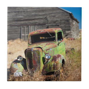 Verrostendes Auto vor verlassenem Bauernhof Fliese