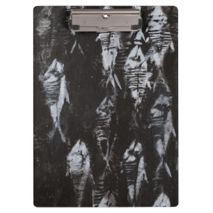 Versteinerte weiße Fische auf schwarzem Klemmbrett