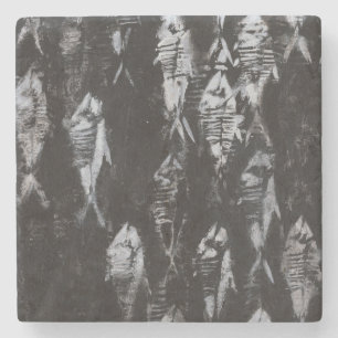 Versteinerte weiße Fische auf schwarzem Steinuntersetzer