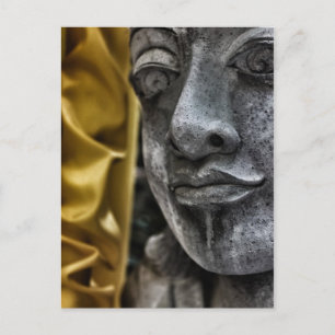 Verwittertes Statuengesicht und gelbe Seidenpostka Postkarte