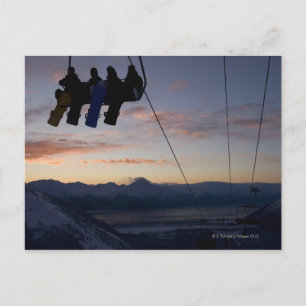 Vier Snowboarder sind auf einem Skilift silhouetti Postkarte