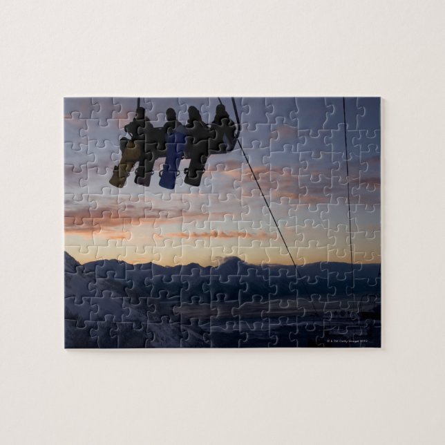 Vier Snowboarder sind auf einem Skilift silhouetti Puzzle (Horizontal)