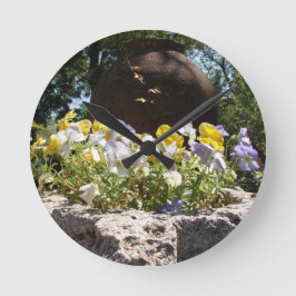 Violas in einem Steintrog. Runde Wanduhr