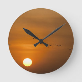 Vögel fliegen bei Sonnenuntergang Runde Wanduhr