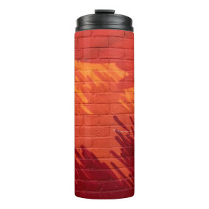 Wand aus rotem und orangefarbenem Ziegelstein Thermosbecher