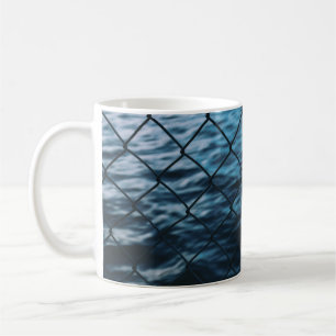 Wasserkörper vor dem Zaun der Kette Kaffeetasse