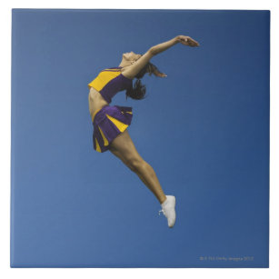 Weibliche Cheerleader, die in einer Luft, Fliese