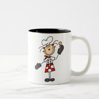 Weiblicher Koch mit Mitten und hölzernem Löffel Zweifarbige Tasse