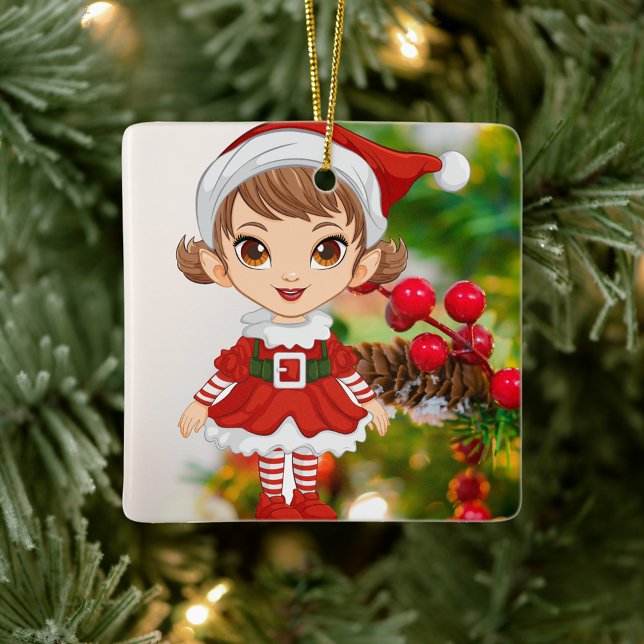 Weihnachts-Elf-Keramik Keramikornament (Elf is dressed in a festive red and white outfit, stands against a backdrop of a decorated tree.)