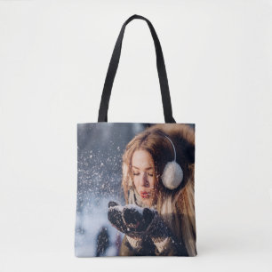 Weihnachts-Wintermädchen bläst in ihrer Hand Schne