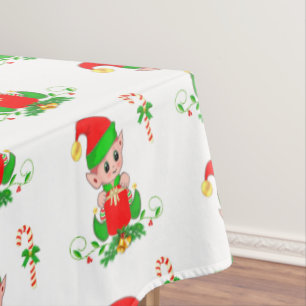 Weihnachtself und Zuckerstange auf weißer Tischdec Tischdecke