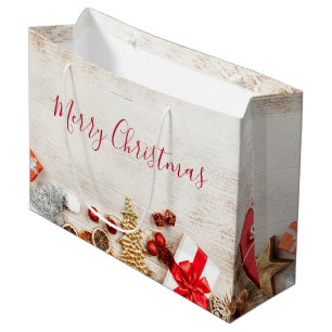 Weihnachtsgeschenkartikel auf einem rustikalen Hol Große Geschenktüte