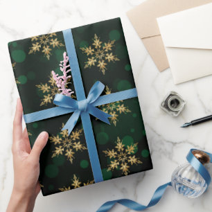 Weihnachtsgoldene falsche Folien-Schneeflocken auf Geschenkpapier