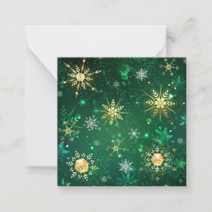 Weihnachtsgoldschneeflocken auf grünem Hintergrund Mitteilungskarte
