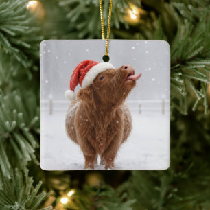 Weihnachtshochlandkuh fängt Schneeflocken Keramikornament