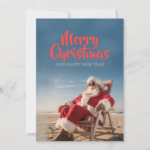 Weihnachtsmann entspannt auf Strandstuhl Feiertagskarte