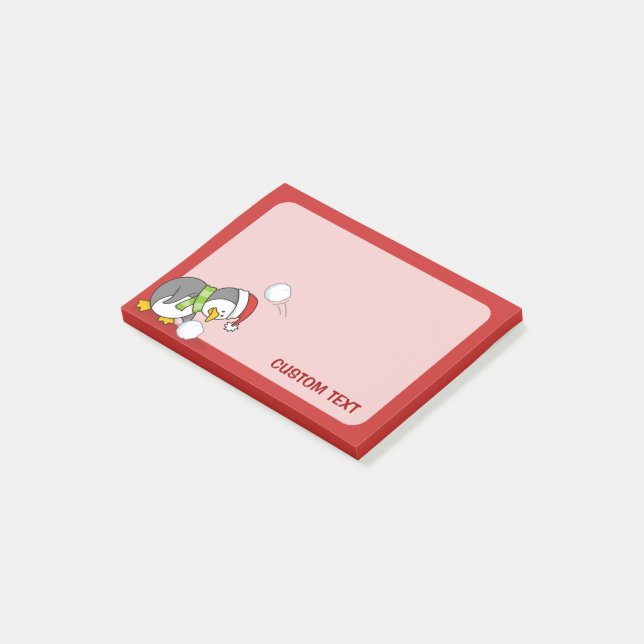 Weihnachtspinguin bekommt eine Schneeball Post-it Klebezettel (angewinkelt)