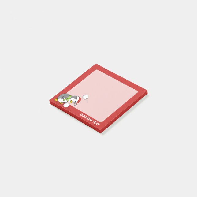 Weihnachtspinguin bekommt eine Schneeball Post-it Klebezettel (angewinkelt)