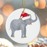 Weihnachtsweiße Elefant Party Niedlich Keramik Ornament<br><div class="desc">Niedliche Ferientiere sind mein Lieblingsteil der Weihnachtszeit. Ein wunderschöner Elefant,  der eine rote Weihnachtsmannmütze trägt und glücklich aussieht. Das erfüllt mich mit dem Weihnachtsgeist.</div>