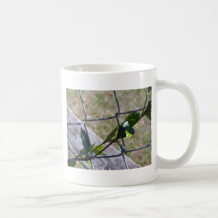 Weine auf einem Kettenzaun finden Leben einen Weg Tasse