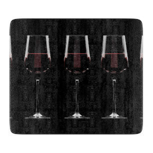 Weingläser mit Rotwein auf schwarz Schneidebrett