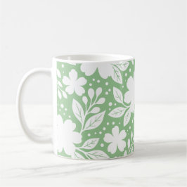 Weiße Blumengestaltung auf weichem grünem Hintergr Kaffeetasse