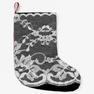 Weiße Blumenspitze auf schwarzem Hintergrund. Kleiner Weihnachtsstrumpf