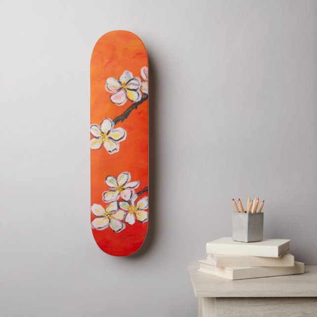 Weiße Blüten auf orangefarbenem Federhintergrund Skateboard (Wandkunst)