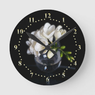 weiße Freesie in einem Glas Runde Wanduhr