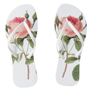 Weiße Hausschuhe einer Rose in jedem Fuß Flip Flops