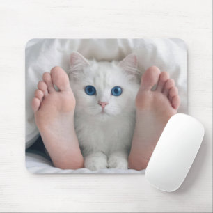 Weiße Katze und menschliche Füße unter einer Daune Mousepad