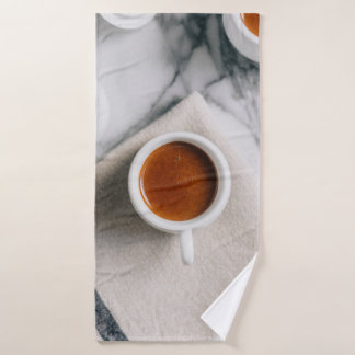 WEIßE KERAMIK-TEETASSE GEFÜLLT MIT ROTER FLÜSSIGKE BADEHANDTUCH