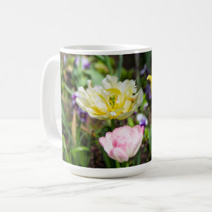 Weiße, rosa und gelbe Tulpen im Garten Kaffeetasse