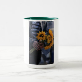 Weiße Tasse, auf der eine Hand Sonnenblumen mit AJ Tasse
