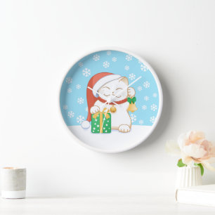 Weiße Weihnachtskatze in einem Red Hat Uhr