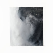 Weiße Wolken über den dunklen felsigen Bergen