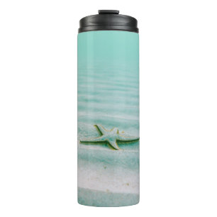 Weißer Seestern auf Sand unter Wasser am Morgen Thermosbecher