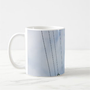 WEIßER STAHL-ELEKTRIKMAST UNTER WEISSEN WOLKEN KAFFEETASSE
