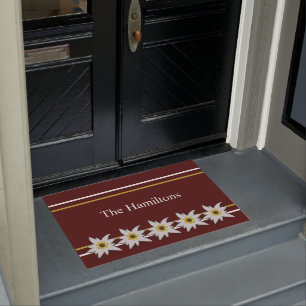 Weißes Edelweiss auf roter Türmatte