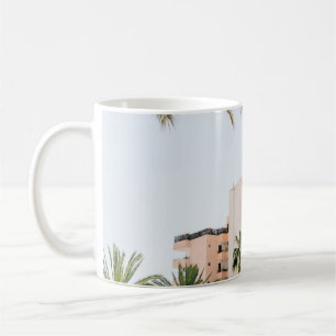 WEISSES KONKRETES GEBÄUDE NEBEN GRÜNEN PALMBÄUMEN KAFFEETASSE