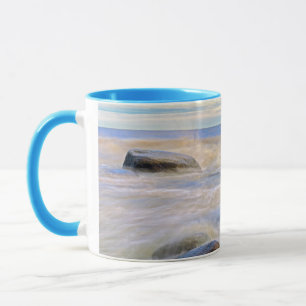 Wellen, die auf Felsen an der Küste stürzen Tasse