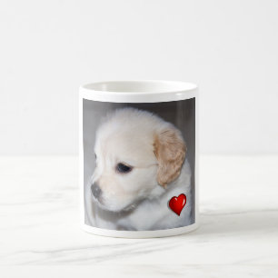 Welpe des goldenen Retrievers mit einer roten Tasse