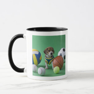 Welpe umgeben durch Sportbälle Tasse