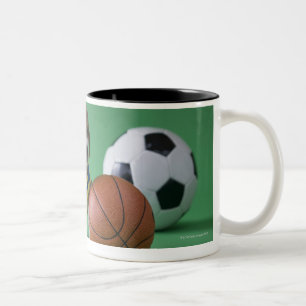 Welpe umgeben durch Sportbälle Zweifarbige Tasse